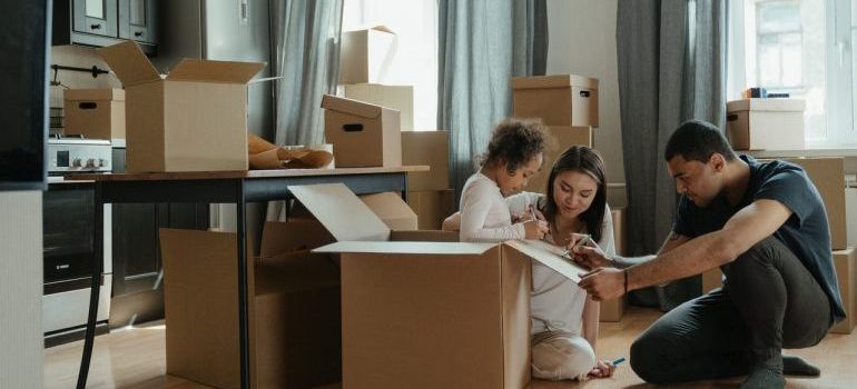 Family packing for a move, surrounded by boxes, waiting for local movers in Michigan