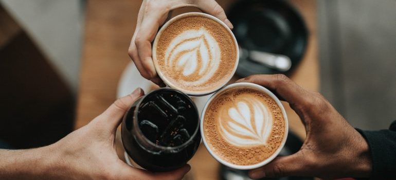 Hands holding coffee cups.