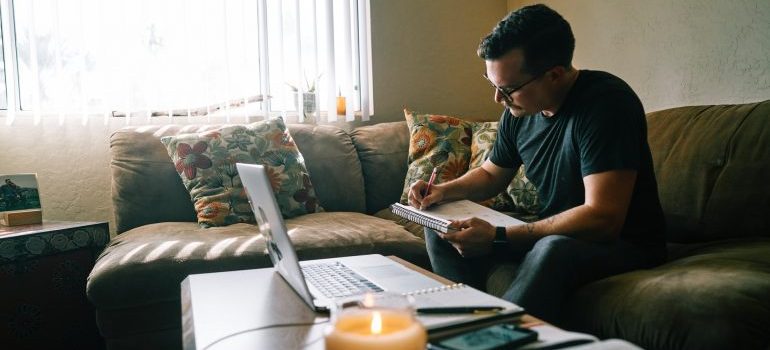 A man writing on the couch