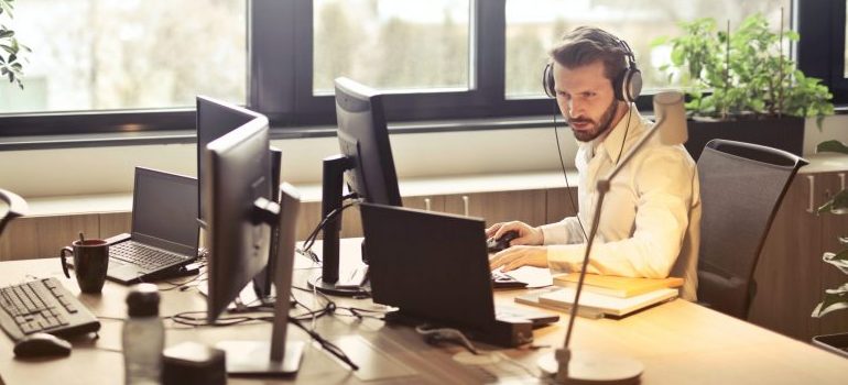 man-with-headphones-facing-computer-monitor