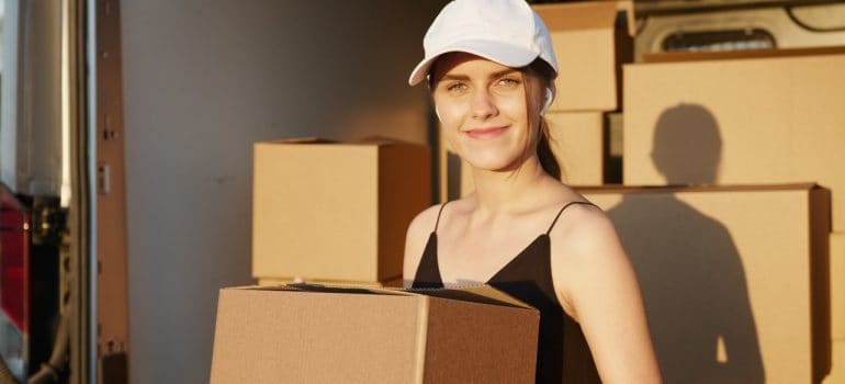 A woman holding a cardboard box.