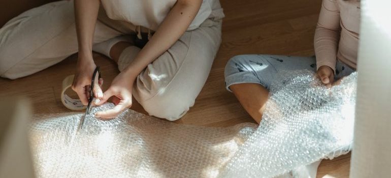 A mother and daughter handling packing materials.