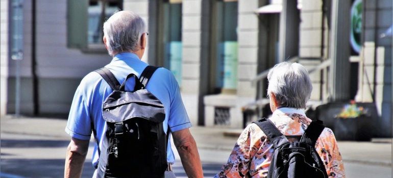 Two elderly people walking on a street