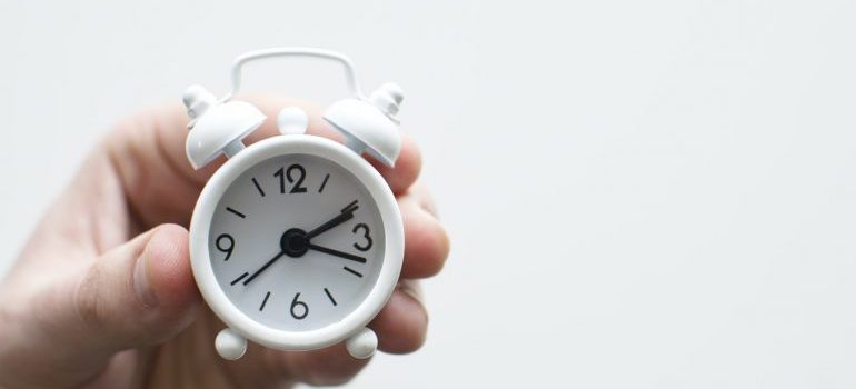 A man holding a small clock