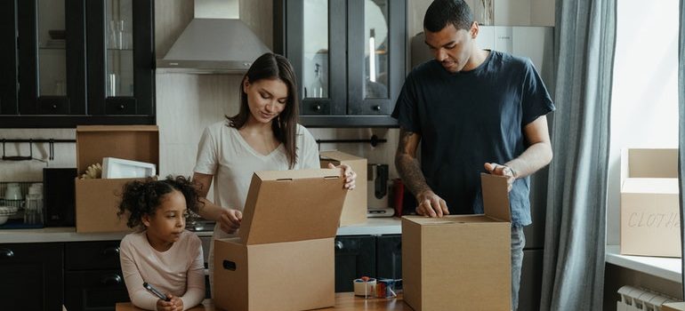 A family packing items in cardboard boxes.