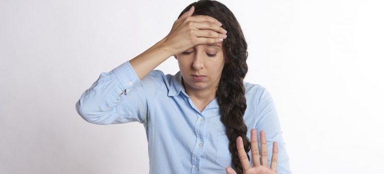 A woman holding her forehead.