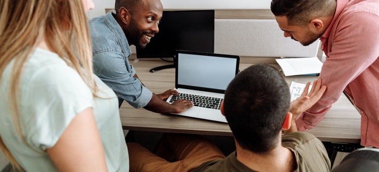 People in an office looking at a laptop.