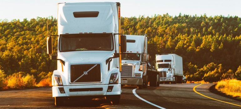 White Volvo semi trucks no the road that can help you with moving from Michigan to Florida