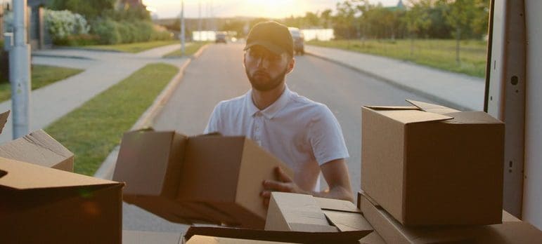 A person loading cardboard boxes into the truck