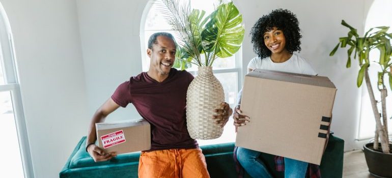 A couple holding their belongings during a move.