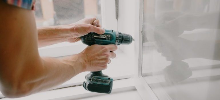 A person putting aapart a piece of furniture gently since they know how important disassembling furniture while moving carefully is very important.