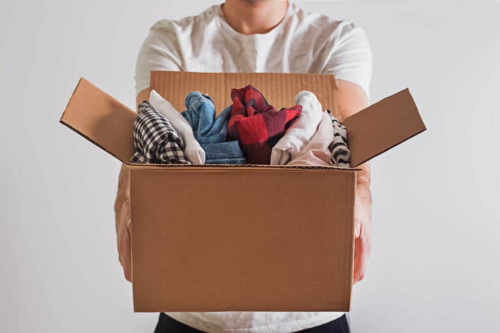 Close-up shot of man's hands holding a box with clothes